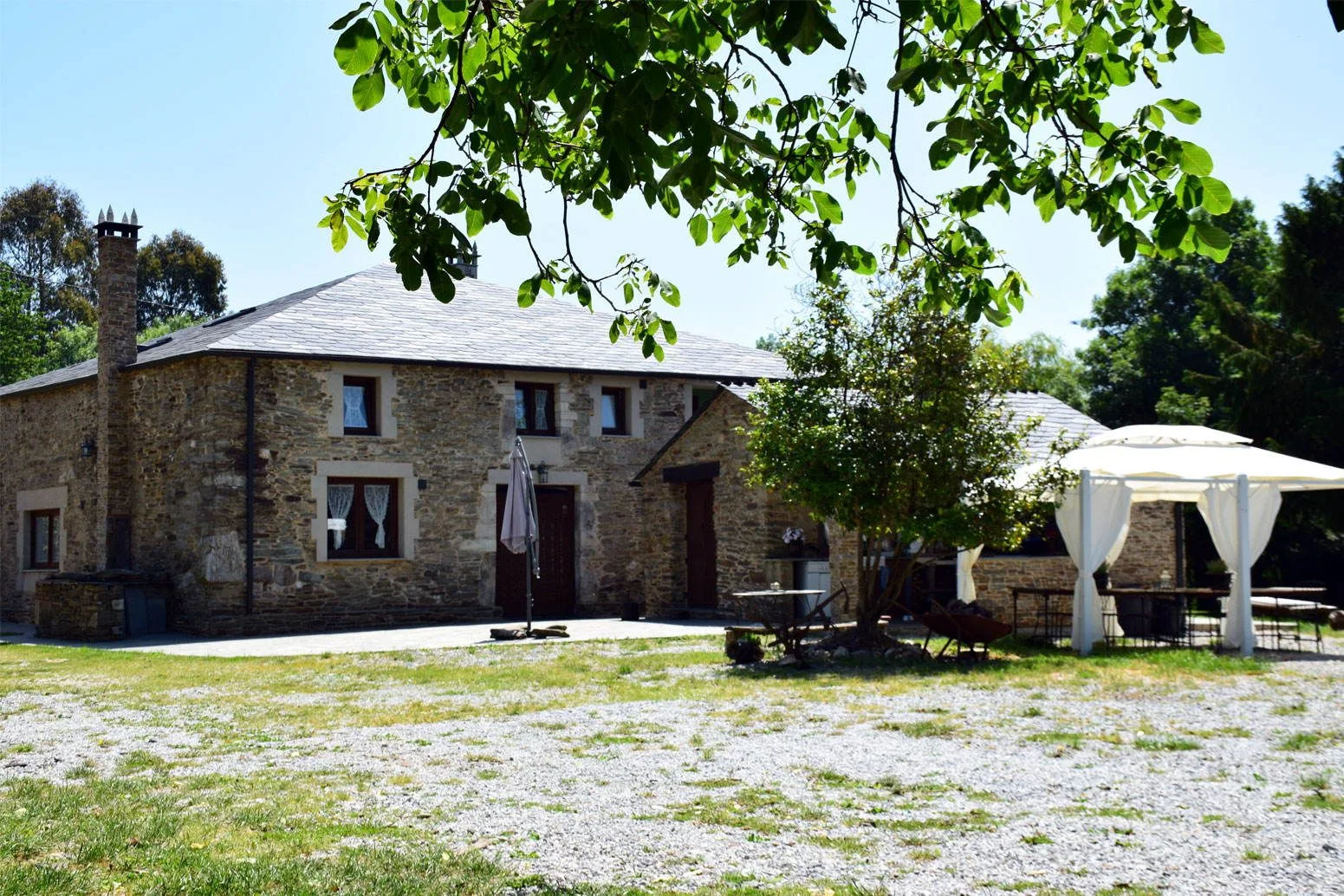 Casa Cuadrado: casa de piedra gallega rodeada de árboles y pradera