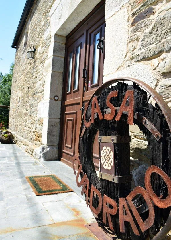 Entrada con la rueda de carro grabada con el nombre de la casa
