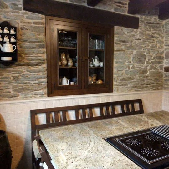 Cocina rústica con cocina de leña y alacenas
